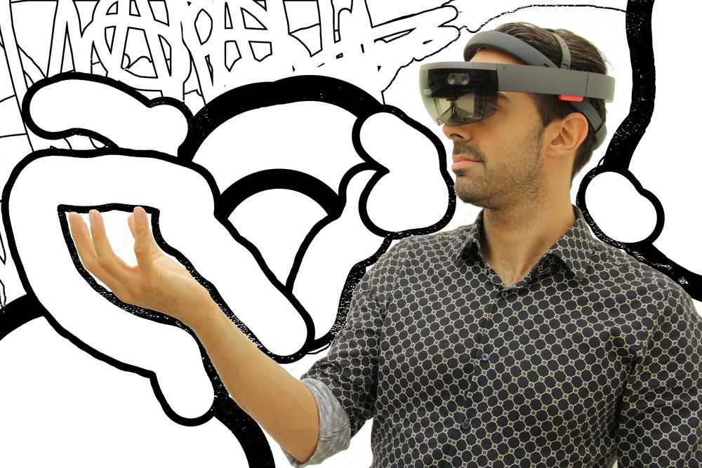 Joram Schito exploring mixed reality with a HoloLens headset in front of a mural